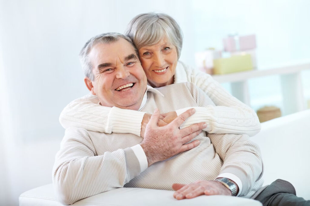 What We Offer: An elderly couple embracing on a couch.