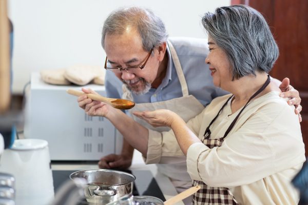 Asian couple preparing food in the kitchen.